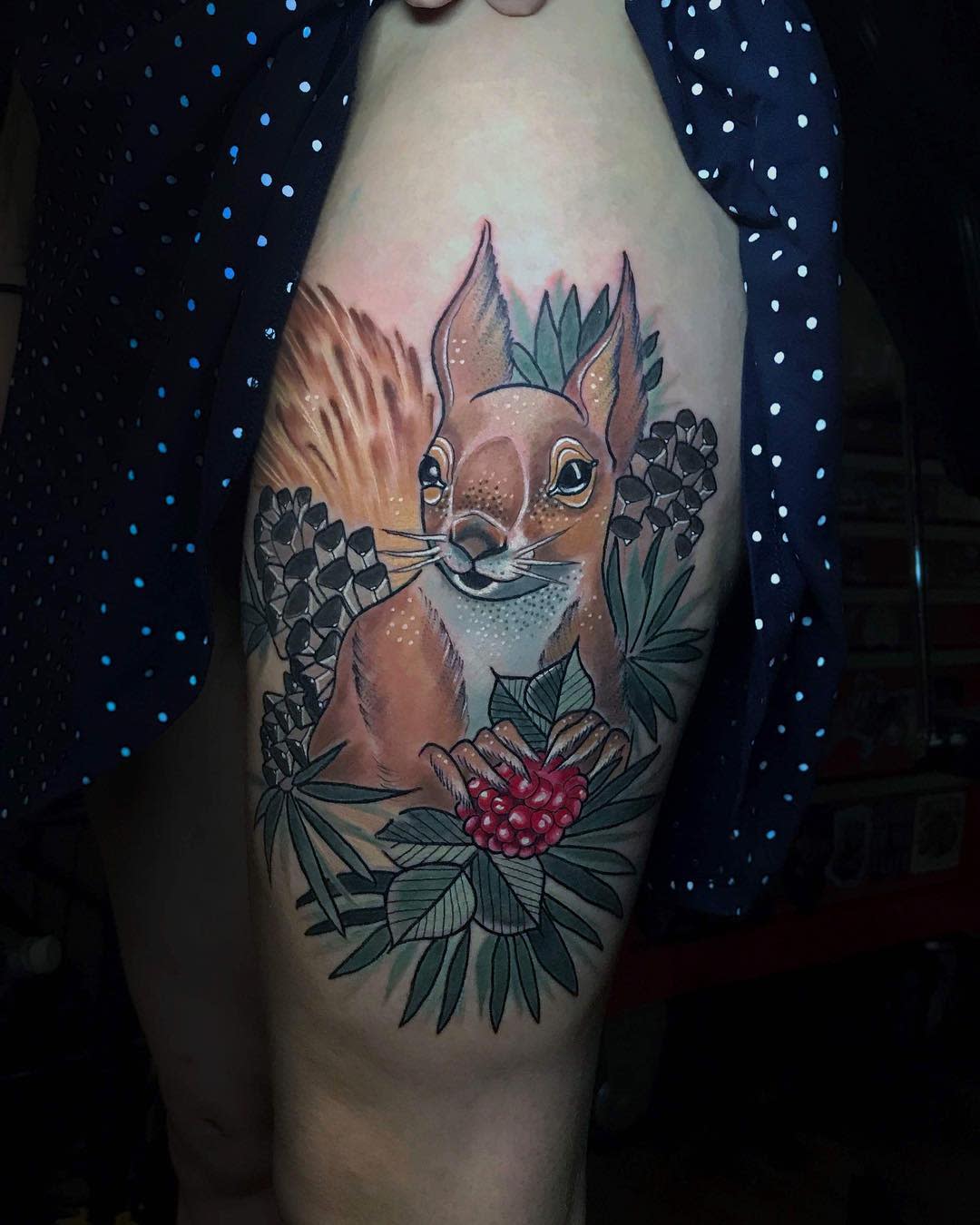Tattoo of a squirrel with pinecones and leaves on an upper thigh